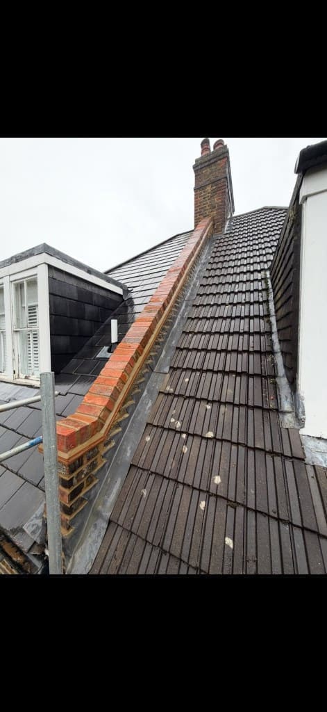 Rebuilt brick parapet wall with dog-tooth course and lead flashing